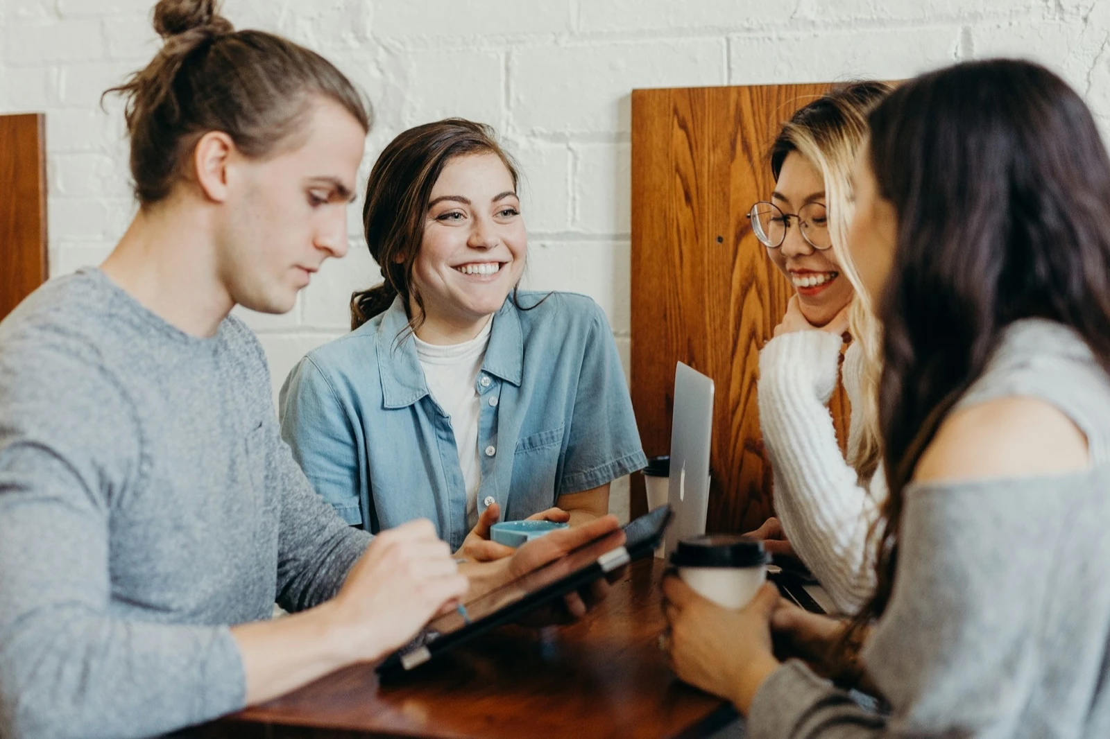 Small group of people gathered around a table, talking